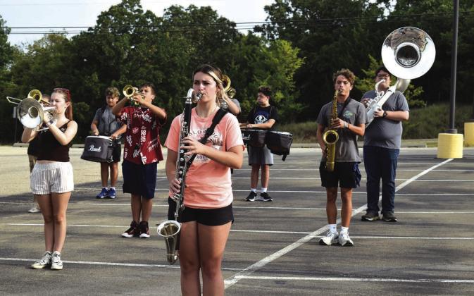 Alexa Gregory (peach shirt) and other members of the Spirit of Stroud marching band practice in the parking lot of the Route 66 Colliseum on Aug. 6 during their week-long band camp. Photo/Emily Kalka