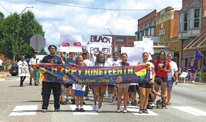 Local residents gather together to march down Manvel Avenue in Chandler on Saturday, June 20, in celebration of Juneteenth. Citizens for the Improvement of Chandler held a special gathering on the lawn of the Lincoln County Courthouse to kickoff the event, which included song, dance, poetry and speeches. Dozens showed up to the event and joined in the march down to Reed Park. Pictured at the front are Todd Thompson, Landon, Rachelle Thompson, Clara Bobo and Brianna Taylor. Photo/Emily Kalka
