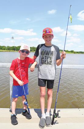 Right, the Chandler Lions Club poses with the new fishing dock that was installed on Chandler Lake last week. Above, anglers Ryatt and Ridley Bendele wasted no time in putting it to good use. Photos/Brian Blansett