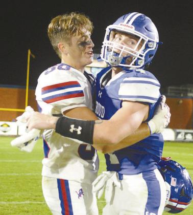 Above, Chandler’s Maddox Metheny (50) and Stroud’s Jacob (4) greet each other after the game. Both are seniors and had just played the last Chandler-Stroud game of their careers. Photo/Brian Blansett. Below, Aiden Collins balances on one hand before recovering and picking up additional yards. Photo/Beth Young