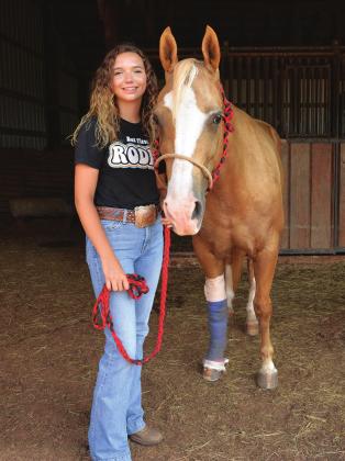 Kenzie Cowden, of Chandler, with her horse, Peaches, who is recovering from an attack by either a mountain lion or wild dogs. Kenzie and Peaches competed in the International Finals Youth Rodeo in Shawnee a few days before the attack. Photo/Brian Blansett