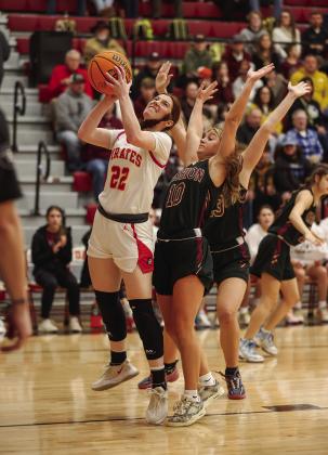 Above, Stroud’s Charley Coleman (20) drives to the baseball against Meeker’s Aviary Helms (00) during regional action at Stroud. Photo/Brian Blansett. Below, Dale’s Brook Rutland puts up a shot against Cashion’s chorus line defense. Photo/Rick Hester.