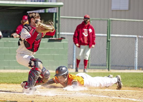 Wellston’s Ryan Gregg slides home with a run against McLoud during the semifinals of the Mark Howard Memorial Tournament in Chandler last week. Catching for McLoud is Jason Key. McLoud won, 11-1, and advanced to the championship game against Ada. Photo/Jeremy Self