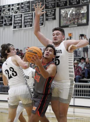 Above left, Kage Danker (21) puts up a shot against the defense of Meeker’s Ean Watham during the Tiger’ 11-point win. Above right, Chance Sanders (20) splits the Meeker defense. Picutred are Ean Watham (23) and Bobby Brooks (35). Photos/Brian Blansett
