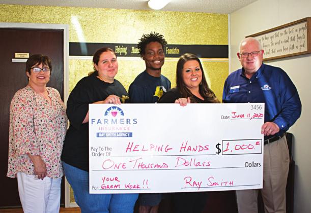 Pictured to the right, from left to right: Tracy Smith, Cassondra Wright, Thomas Denson, Sabra Denson and Skip Wright stand with the $1,000 donation at the new Helping Hands Foundation store front. Photos/Chelsea Weeks.