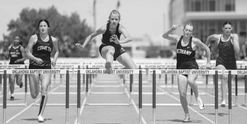 Aubree Ackerman (center) from Stroud clears the final hurdle on her way to winning her heat in the 100mm hurdles at the OBU track meet last week. On the right is Elli Hilgenfeld of Chandler. Photo/Mario Holland.