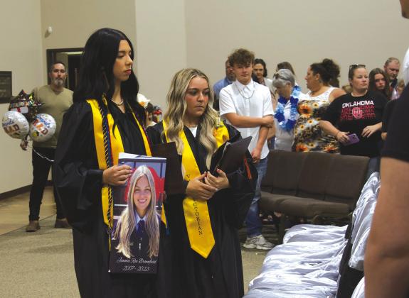 Davenport graduates Helen Orr (left) and Landry Miller (right) honor their classmate Jimmie Brownfield, who passed away in August 2023, at their graduation ceremony on May 14 at First Baptist Church in Davenport. Photo/Emily Kalka