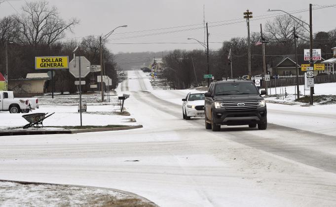 A thundersleet storm moved through the area Monday morning, coating roads and parking lots and forcing many area schools to close in-person classes and go to virtual classrooms. This scene is looking east on state Highway 62 from the four-way in Meeker. Photo/Brian Blansett
