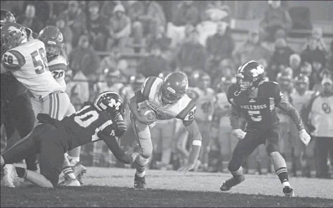 Above, Meeker’s Jarrett Marks (10) and Dakota Gabbert (5) bring down Chandler runner Casmen Hill (5). Photo/Brian Blansett