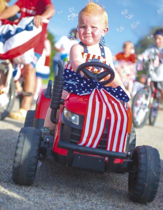 Colter Plunket from Meeker had a stylish ride in the first annual patriotic parade at the Meeker’s Independence Day celebration at Meeker Lake Friday. Not only was it tricked out in red, white and blue, it had a bubble machine in the back. Photo/Brian Blansett