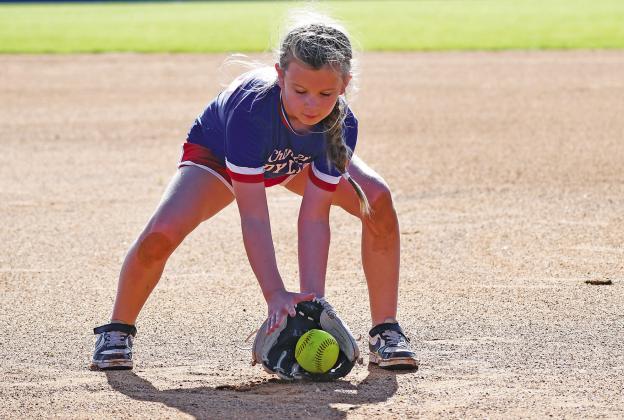 A field full of girls showed up for the annual Chandler softball camp last week. Above, Dani Weber participates in a fielding drill. The campers also worked on fielding (left) and took part in a spirited bunting game (below left). Photos/Brian Blansett
