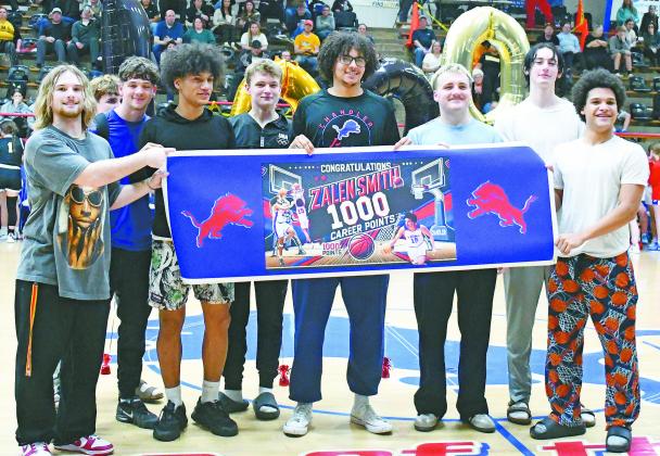 Chandler’s Landon Earp, at left with his parents, Jaclyn and Shane Earp, recorded his 100th career wrestling victory last week in less than three full seasons of high school competition. A junior, he qualified for the state tournament as a freshman and sophomore. For more, see Page 1C. Photo/Jennifer Pryor. Senior Zalen Smith, pictured above with his teammates, scored the 1,000th point of his career in the Lions’ win over Tecumseh Friday. He was at 999 points and put in a bucket from the lane in the first q