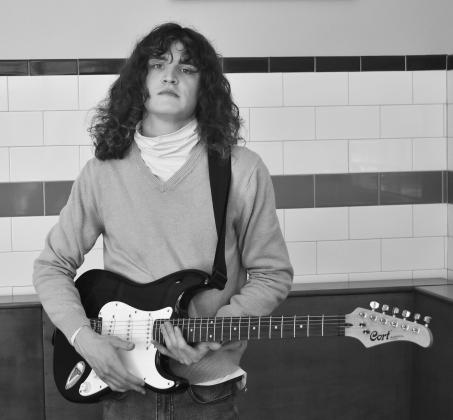 Austyn Denmore, with his rockstar haircut, holds his electric guitar. Photos/Bradey Jager