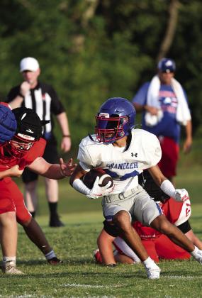 Above, Ty Garver provided one of the highlights of the Chandler-McLoud scrimmage last week when he snatched an interception away from the Redskins’ Zaylun Matlock. Below, getting some turns carrying the ball are Lions Clayton Ritchie, left, Grant McGinnis, center,and Felix Cargill, right. Both teams scrimmage again this week, with Chandler hosting Meeker on Thursday and McLoud hosting Shawnee. Photos/Brian Blansett
