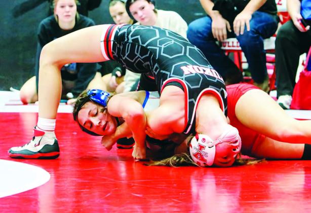 Chandler sophomore Lizzy Pryor (in red and white) nears a pin against Abigail O’Kelly of Yukon during the Wrestle Like a Girl meet at Cache. Pryor took fourth in her class and McKinley Miller won sixth. See more wrestling photos on Page 3D. Photo/Jennifer Pryor