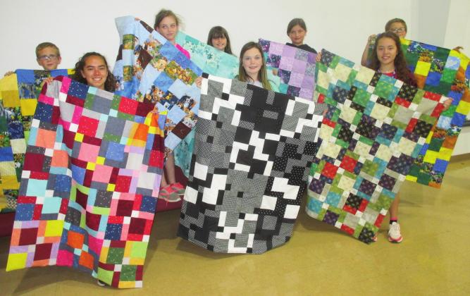 Students hold up quilts they made at the Meeker Quilters’ Guild’s 12th annual summer quilt camp. In the front row, from left, are Brittany McDoulett, Meeker, Abbie Perry, Meeker, and Mariah McDoulett, Meeker. In the back row are Noah Ray, White Rock, Bella Borcherding, EPIC, Brisyn Tipton, Olivia Jones, home school, and River Wooten, White Rock. Not pictured are Addie Tipton, Meeker and Allie Jarvis, Meeker.