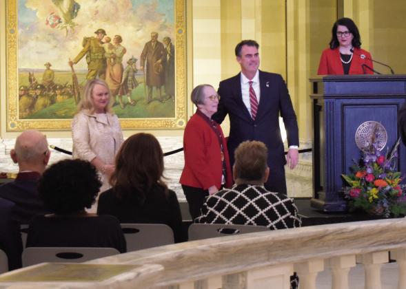 Jana Telford (center), a music teacher from Chandler, receives a Governor’s Arts Award for Arts in Education from Gov. Kevin Stitt (right of Telford) at a special ceremony at the State Capitol on Jan. 30. To the far left is Tracie Chapman, chair of the Oklahoma Arts Council who emceed the event, and to the far right is Amber Sharples, the executive director of the Oklahoma Arts Council who announced the awards. Telford is one of five educators who received the award. Photo/Emily Kalka