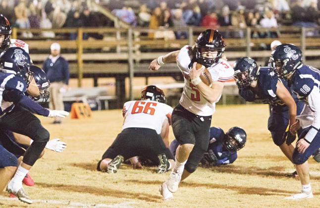 Davenport quarterback Carson Funk (5) bursts through a hole cleared by Cruz Hillian (66) and Casey Harrelson (40) Friday night at Summit Christian. Photo/Adam Ewing.