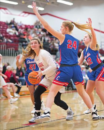 Right, Prague’s Diana Manning (35) eyes the bucket over the defense of Chandler’s Selah Bryan (24) during the finals of the 66 Conference tournament. Photo/Brian Blansett