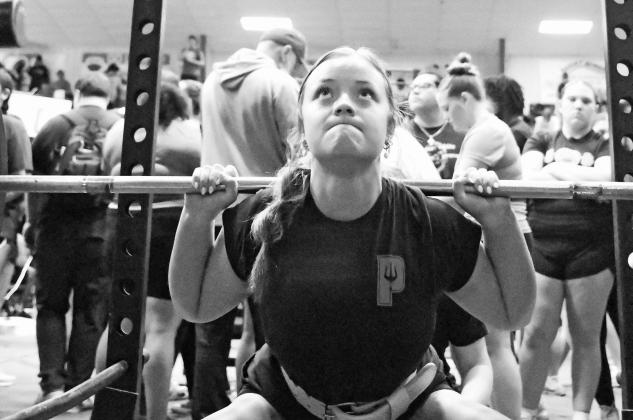Above, Emily Hinkle from Prague competes in the squat at the Lion Invitational powerlifting meet, held at Chandler High School on Wednesday. She lifted 255 pounds in the event and finished second overall in her class. Below left, Clara Lif from Carney competes in the deadlift. She lifted 260 pounds in the event and finished second overall in her class. Bottom right, Karlea Wright from Carney competes in the bench press. Photos/Brian Blansett