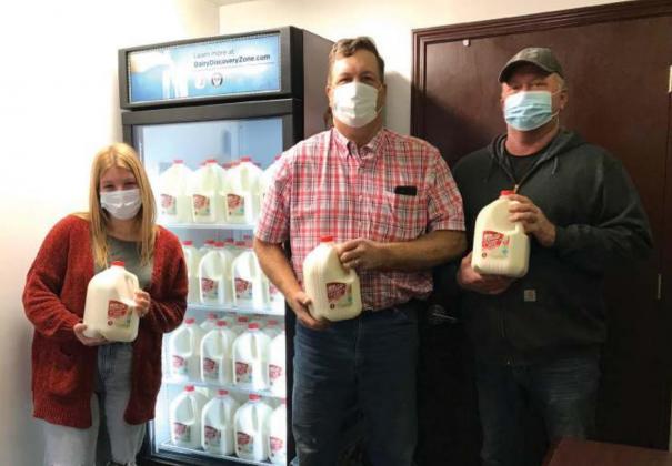 Pictured above, Delaney Haley, Steve and Kevin Ricker stand with jugs of donated milk to the Helping Hands Community Foundation. Photo/submitted.