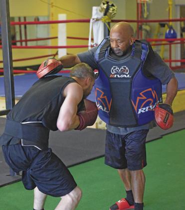 Tracy Sneed, gym owner and retired professional boxer from Chandler, trains his athlete in a pad hitting session as he commands when to punch and parry. Photo/Jentezen Smith