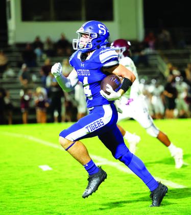 Above left, the Tigers run through the banner and on to field before playing Kellyville Friday night. Above right, Jacob Beck heads for the promised land Photos/Beth Young