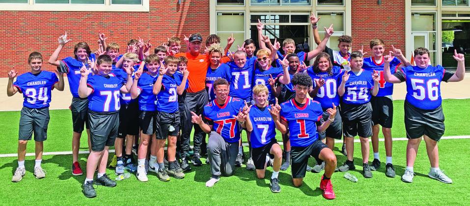 The Chandler Junior High football team went into full Pistols Firing mode last week during a tour of the Oklahoma State University football facilities. The team got to see the weight room, film room, coaches offices, meeting rooms, athletic cafeteria, indoor practice field and Boone Pickens Stadium. After eating, the team was playing football on the outside turf field and OSU head coach Mike Gundy walked by and took this picture with them.