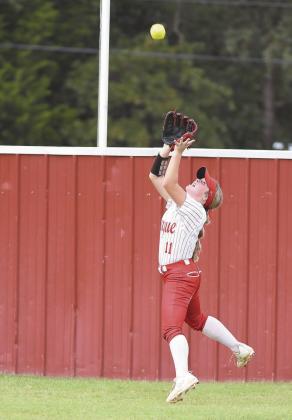Prague centerfielder Dusti Gregory tracks down a long fly ball during the 66 Conference tournament against McLoud. It was one of two fine running catches she made in helping the Lady Devils reach the finals. Photo/ Brian Blansett