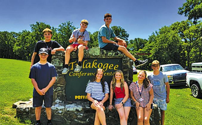 On the left, Kaydence Staude speaks at the raising of the flag ceremony at the Oklahoma FFA Alumni Leadership Camp. On the right are the eight students who participated from Meeker FFA. Photos/Meeker FFA