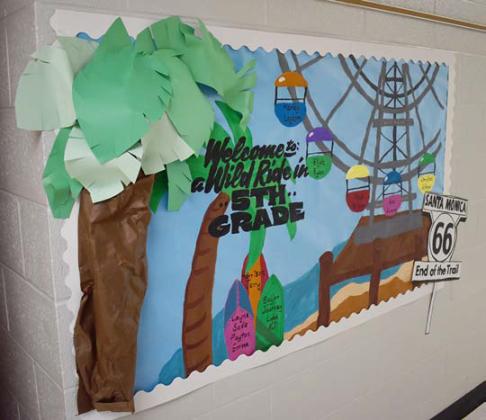 Top: A sign celebrating Route 66 at Park Road Elementary greets students and teachers as they walk into the library. Bottom left: A bulletin board showcasing the Santa Monica Pier -- the end point of Route 66 in California -- graces the fifth-grade hallway at Wellston University. Bottom right: The hallways of Parkview Elementary in Stroud showcase Route 66 and its various landmarks to celebrate the Centennial. Photos/ Emily Kalka
