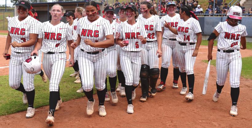 The North Rock Creek Lady Cougars walk back to their dugout after congratulating Hailey Hacker, second from left, on a home run in the state tournament. Eligible for the playoffs for the first time in the school’s short history, they made the most of it, going all the way to the state championship before falling to powerhouse Washington. Photo/ Brian Blansett