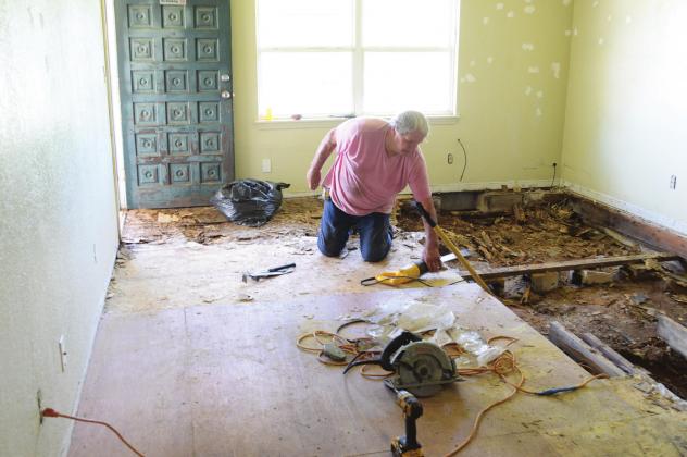 Charlie Wilson of Charlie’s Roofing, Windows &amp;amp; More removes old flooring at a residence on SH 18 north of Chandler. Photo/Kendra Johnson