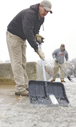 Rodney Barnett, foreground, and Virgil Wilson break ice off the sidewalk at the Lincoln County Courthouse Monday morning following the storm that came through Sunday evening. The second winter storm in a week, it closed schools and offices and the roads in Lincoln and Pott County were slick and dangerous. Photo/Brian Blansett