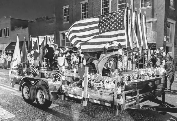 Members of American Legion Post 64 sit amongst the flags on their float in Chandler’s annual Christmas parade and tree-lighting festival that took place on Dec. 6. Photo/Jennifer Pryor
