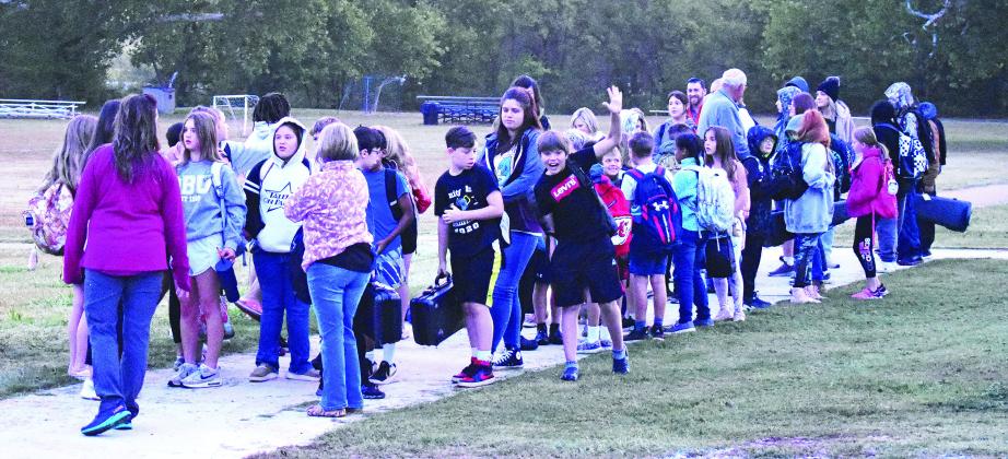 Teachers at Park Road Elementary lead students down the sidewalk during their annual Walk to School event. The walk helps promote wellness and being active. This is the second year the school has participated in the nationwide campaign. Photo/ Emily Kalka
