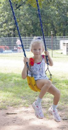 Top Photo: From right to left, Korvyn Herring, Maddox Thompson, Elton Orr, Wyatt Danker and Cayse Spruill play water games at Camp Copperhead. Center: Counselor Lizzy Pryor pushes Ryleigh Jones on a large tire swing. Right: Charlotte Grant enjoys some fun time on the swing set. The camp has been around since 2020, started by triplet sisters Annie, Leah and Jessie Brannon. Photos/Brian Blansett