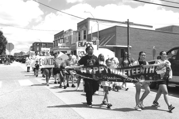 On the left, Elijah, Brianna, Myla, Keiyston, Geneva, Klara and Timburlund perform a Youth Stomp at the Juneteenth celebration on the courthouse lawn. The program was then followed by a march down Manvel all the way to Reed Park on Allison. Photo/Emily Kalka