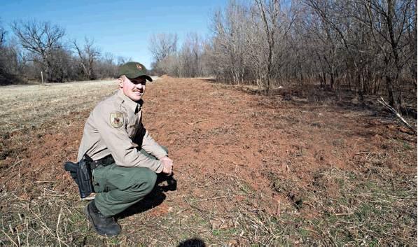Game Ranger Jacob Harriett next to Highway 18 about two miles south of Chandler, where wild hogs rooted up a stretch of soil about 100 yards long. Wild hogs are a continuing, growing problem in Lincoln County. Photo/Brian Blansett