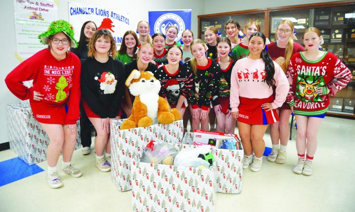 Chandler’s high school cheerleaders collected Christmas presents at the Lions’ wrestling dual and basketball games last week and will give them to the local DHS office, which will give them to foster children in the area. Photo/Brian Blansett