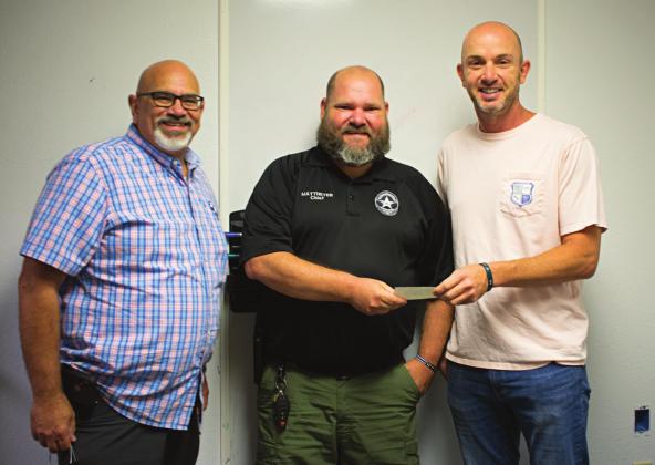 Pictured above, Chandler Ministerial Alliance President John Casey, right, and Treasurer Kirk Holloway, left, presents the check of $18,500 to Chandler Police Chief Matt Matteyer, middle. Photo/Chelsea Weeks