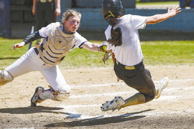 Above, Stroud catcher Cheyanne Messer tags out a Beggs runner at the plate during the Lady Tigers’ district championship. Photo/Beth Young. Below, the Chandler Lady Lions pose with their district championship plaque after taking two of three from Harrah to win the title. Photo/Brian Blansett.