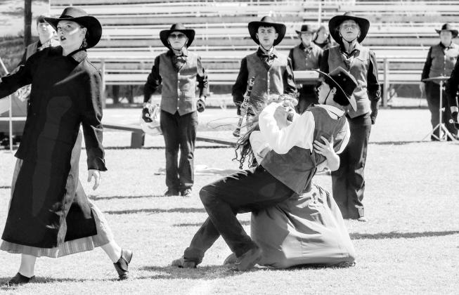 Bethany Descher as Georgia Graves catches Isaac Myers (who plays her husband) as he falls to the ground after being “killed” by Alison Radcliffe (far left), who plays an outlaw in The Pride of Chandler Marching Band’s performance of “The Ballad of Georgia Graves.” The band performed at the Blue and Gold Marching Classic in Holdenville on Saturday. Photo/Jennifer Pryor
