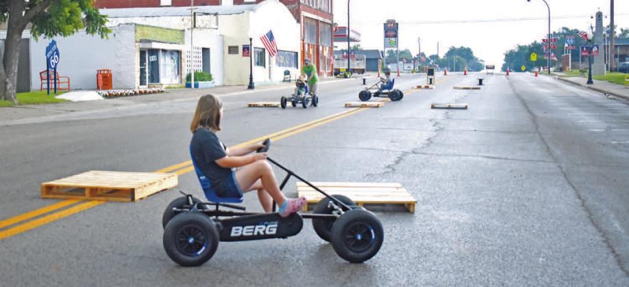 David Timmons helps kids race down Main Street at the Stroud Arts activity area during Stroud Summer Fest on Saturday. Bottom