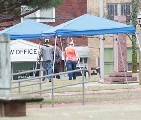 With restrictions on the number of people allowed in the courthouse at one time, the county erected canopies so those who had to wait outside could have shelter from Tuesday’s rain. Photo/Brian Blansett