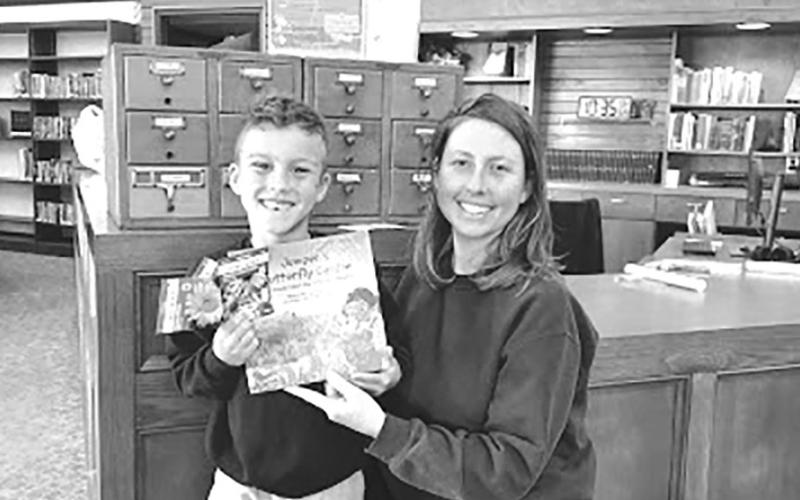Megan and Knox smile in front of the Seed Library at Chandler Public Library. They picked out pollinator flower seeds based on Juniper’s Butterfly Garden book. Vegetable, flower and herb seeds with planting guides are available to all gardeners at the library. All seeds were donated by Lincoln County Farm Center and Friends of the Library. Photo/Sandy Tharp-Thee