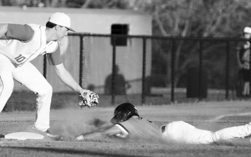 Davenport’s Devin Murfin channels some Pete Rose with a headfirst dive into third base last week against Prague in the Davenport tournament. The third baseman for Prague is Henry Hankins. Photo/Brian Blansett