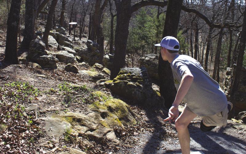 Chandler resident Landon Gray lets his disc fly on a hole affectionately called “The Rattlers” at Stroud’s The Nest Disc Golf Course. The hole gets its name from the rock formations that resemble the pygmy rattlers that live in the area. Photo/Emily Kalka