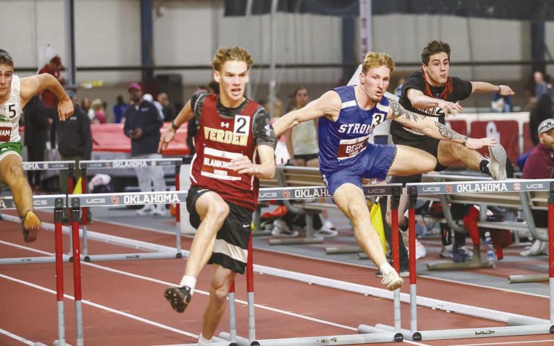 Stroud’s Jacob Beck (in blue) clears a hurdle en route to a state runnerup finish at the Indoor State Championships Saturday at the Mosier Indoor Athletic Facility at OU. The event was sponsored by the Oklahoma Cross County &amp;amp; Track Coaches Association. Photo/Mario Holland