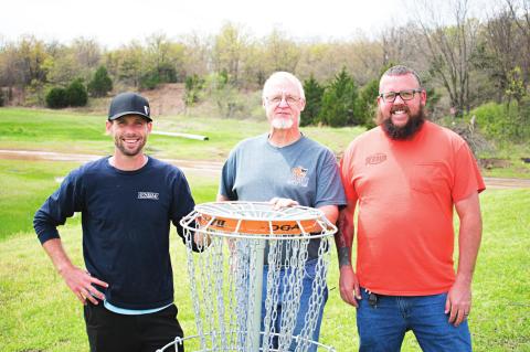 Pictured from left to right: Course Designer Matt Bell, City Manager Bob Pearman and Lake Ranger Jared Null stand by a disc golf basket at the Stroud Lake. Photo/Chelsea Weeks